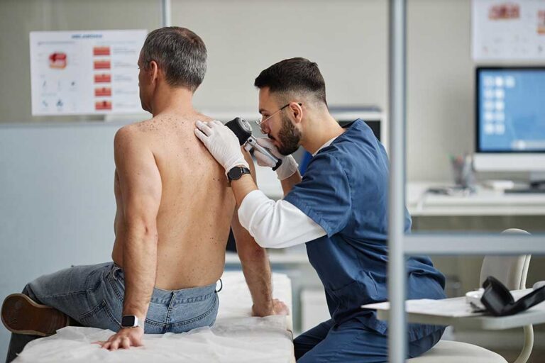 A person gently touching their cheek while looking in the mirror, with mild skin redness visible.